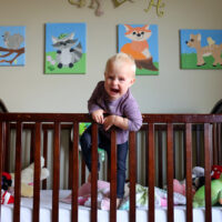 baby climbing out of his crib