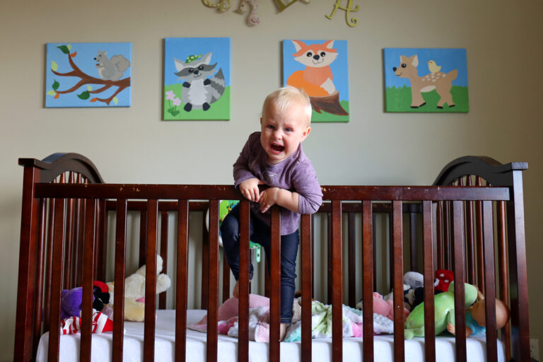 baby climbing out of his crib