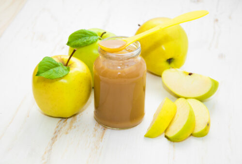 jar of apple baby food with apples surrounding it