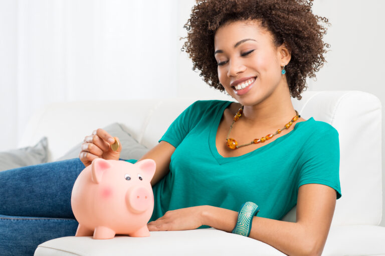 woman putting coin into a piggy bank