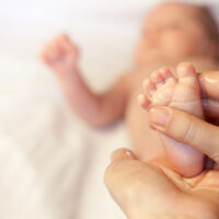 massaging baby oil onto baby foot