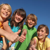 Group of Kids Outside Giving the Thumbs Up