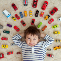 Little boy lying on floor with cars