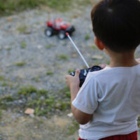 Little boy playing with remote controlled car outside