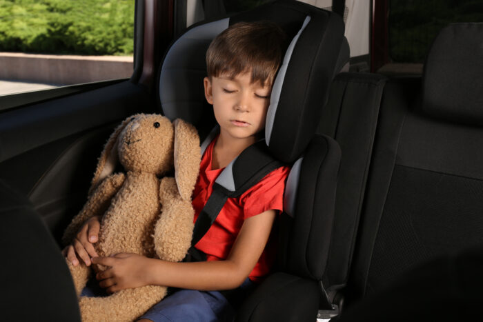 Little boy in car seat with his stuffed bunny