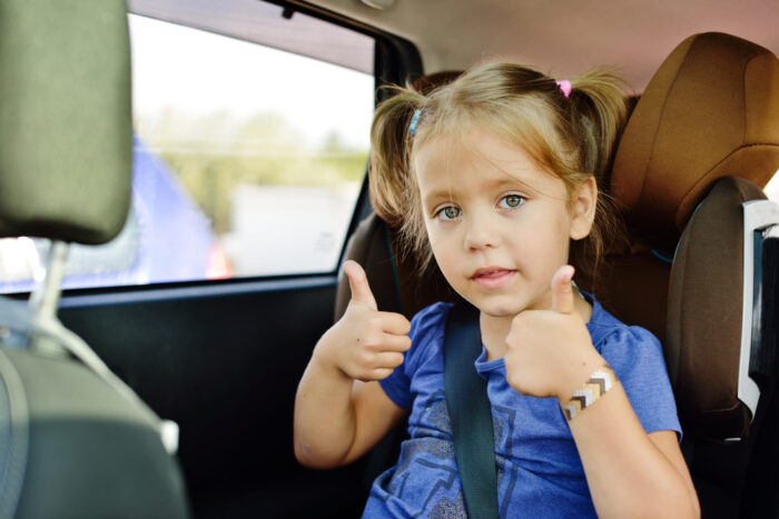 Little girl in high back car seat