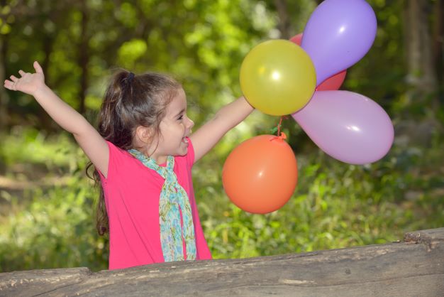 Little girl outdoors playing with balloons