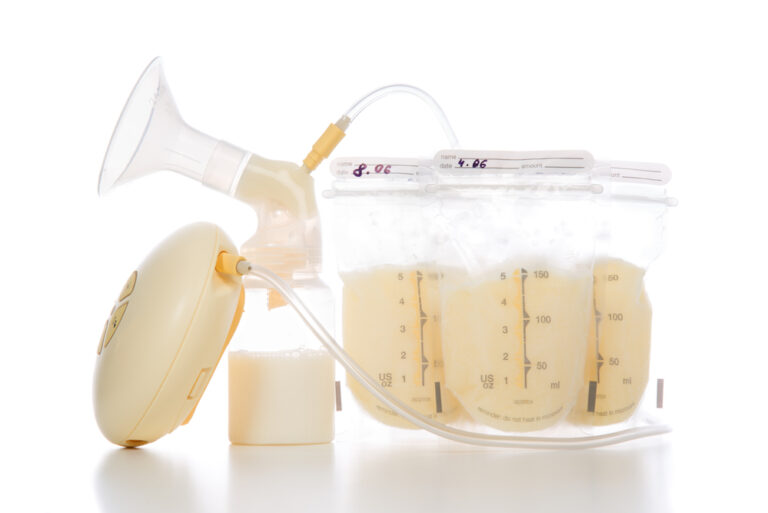 medela breast pump with bags of breastmilk on white background