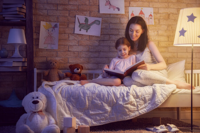 Mom and daughter reading together before bedtime