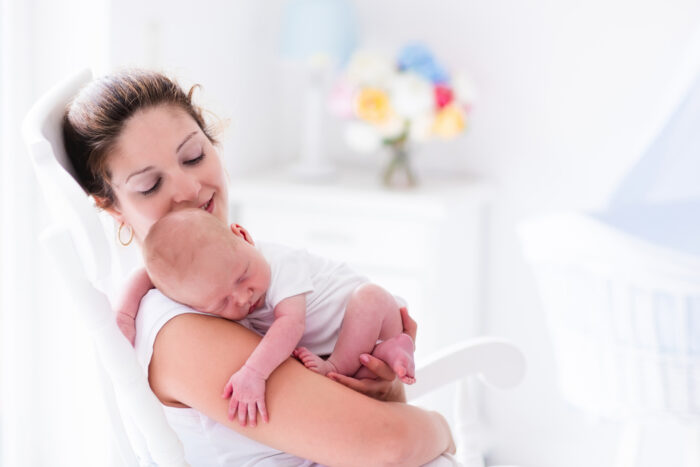 Mom and baby in rocking chair in nursery