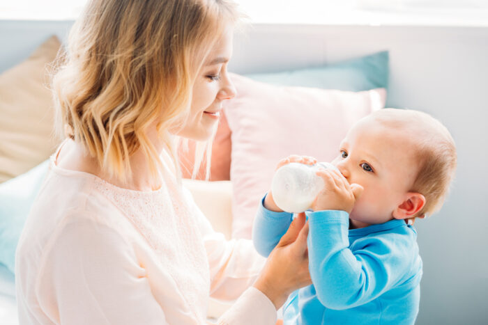 mom holding baby drinking pedialyte