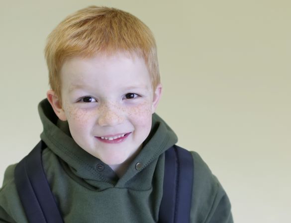 Red haired, freckled school boy with backpack