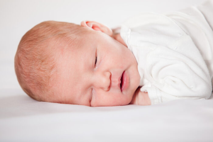 Sleeping baby in white bassinet