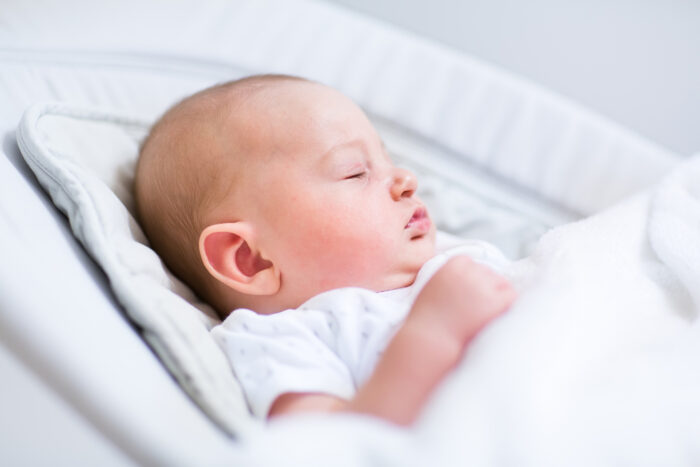 Newborn baby sleeping in baby swing