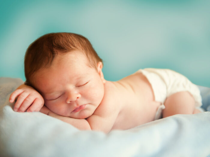 Sleeping baby with green background on green pillow