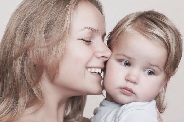 Smiling mom with blonde toddler