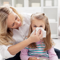 picture of mom helping little girl to blow her nose