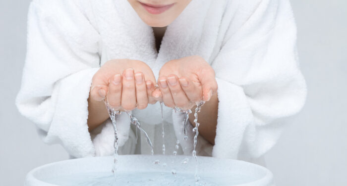 Teen Girl Washing Her Face in Her Bathrobe