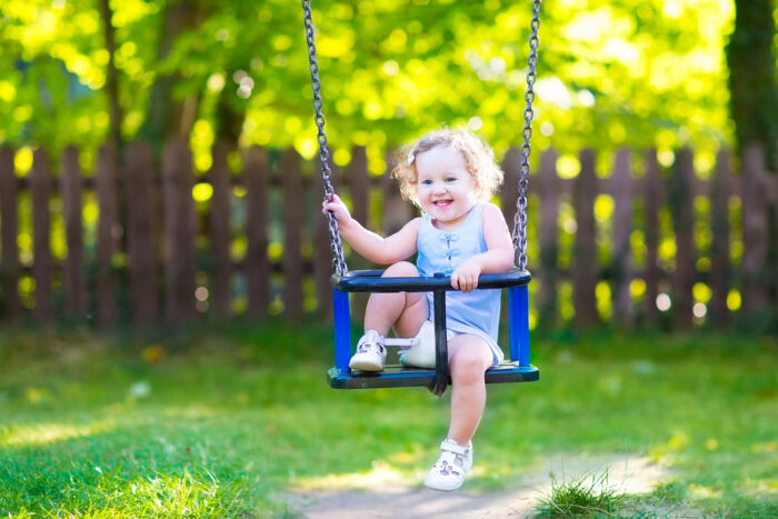 Laughing toddler in outdoor swing