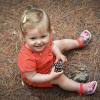 Toddler Sitting in Forest in Sandals