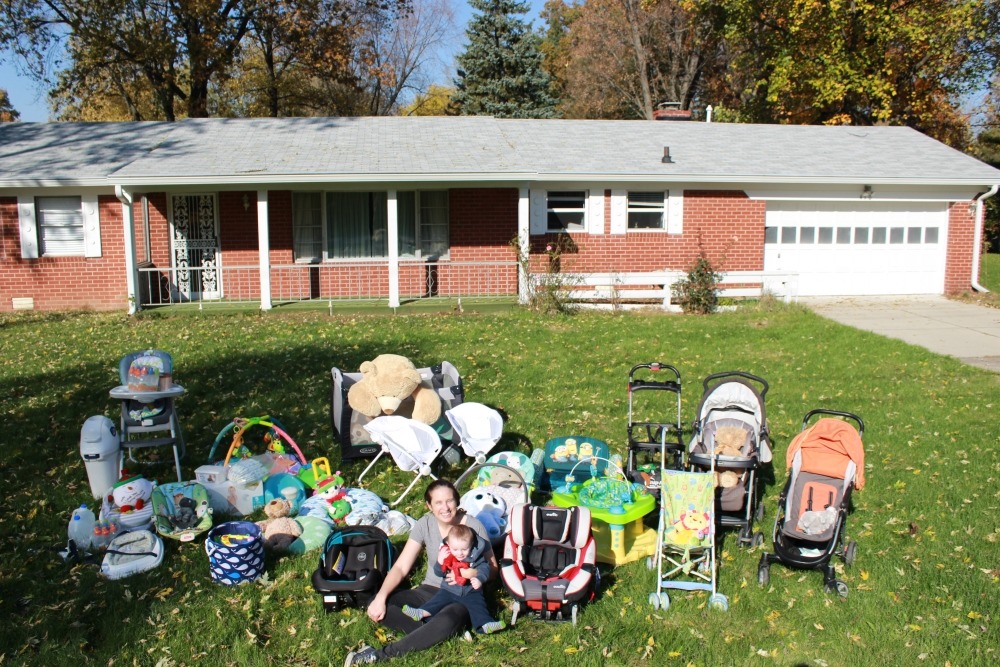 A mom with all of her baby gear out in her front yard.