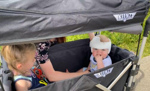 Child in stroller wagon with corrective helmet for flat head condition