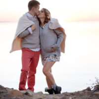couple at the beach enjoying a babymoon
