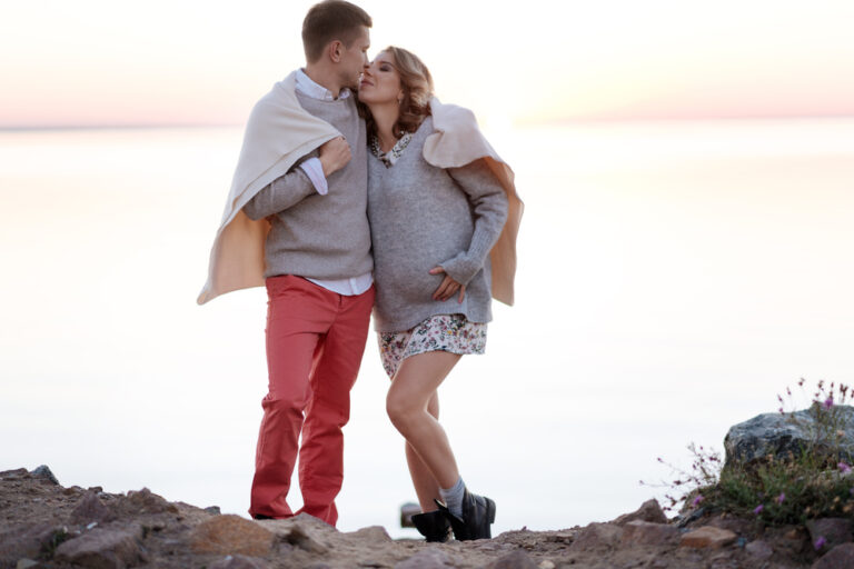 couple at the beach enjoying a babymoon