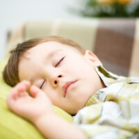 portrait of toddler boy napping on pillow